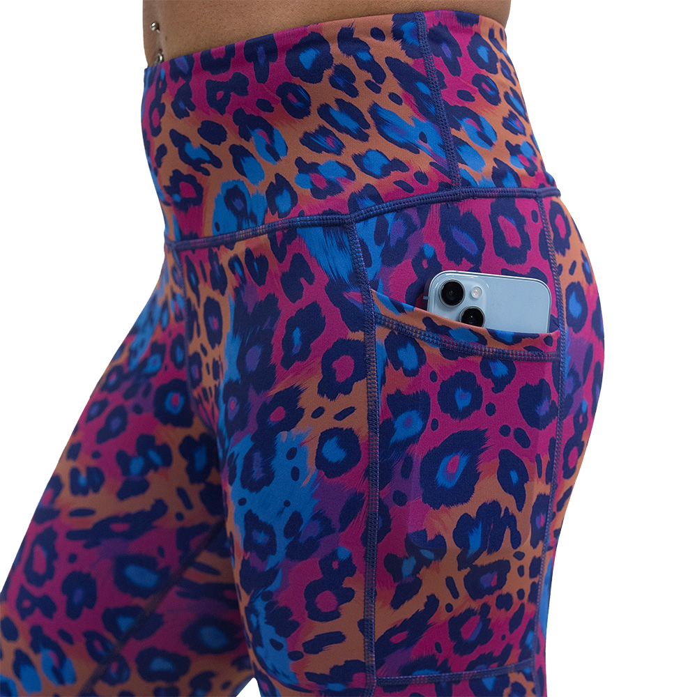 close up of the cheetah print against a yellow, blue, and purple background pattern leggings with a phone in the pocket
