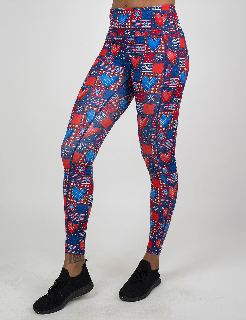 front of the full length red white and blue with hearts and flowers patchwork pattern leggings against a white background