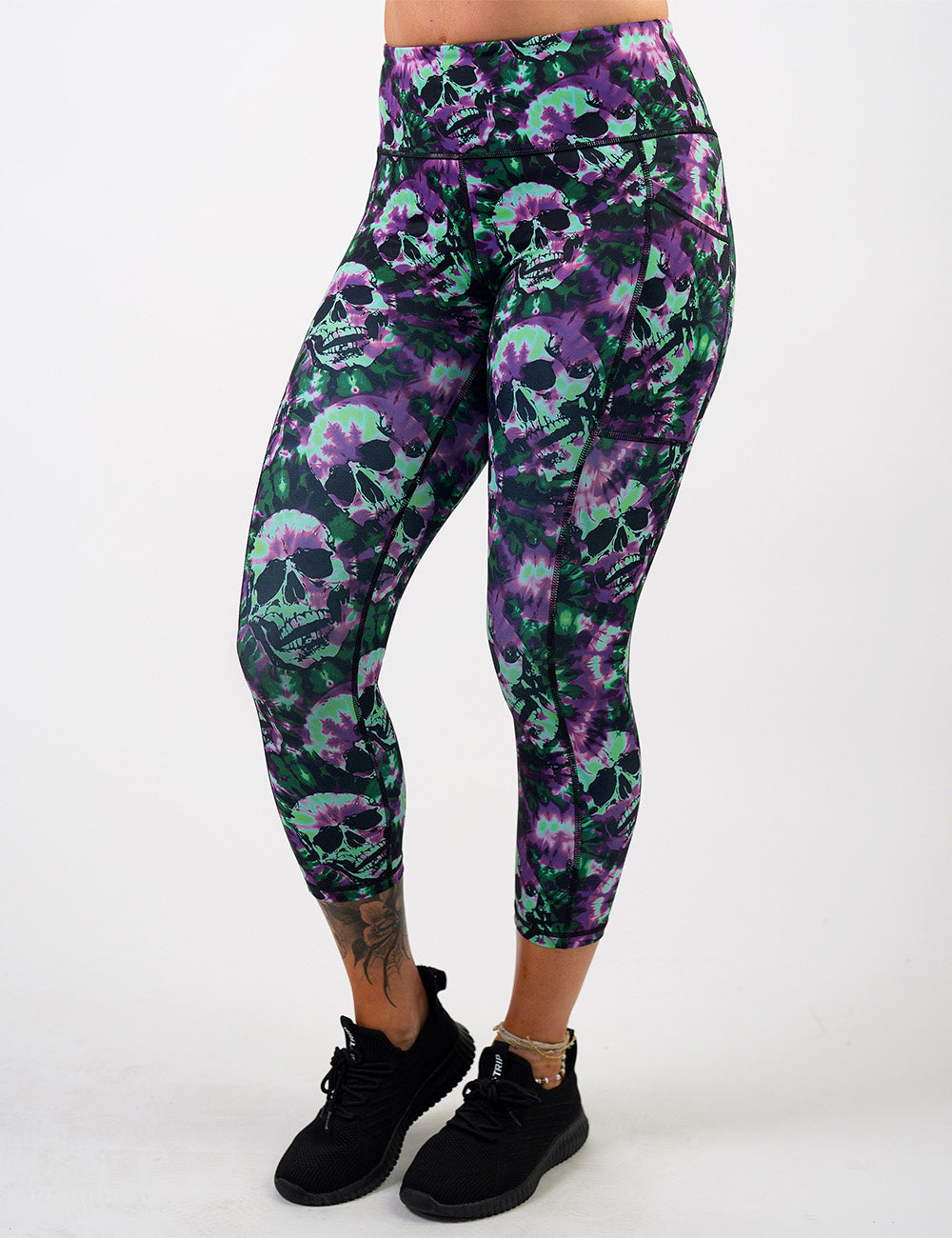 front of the purple and green tie dye skulls capri leggings against a white background