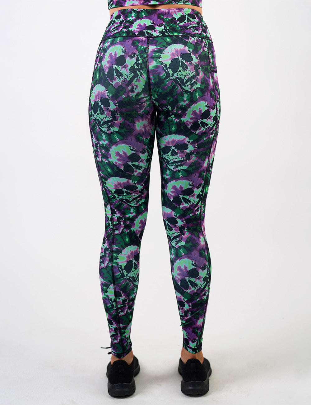 back of the full length purple and green tie dye skulls leggings against a white background