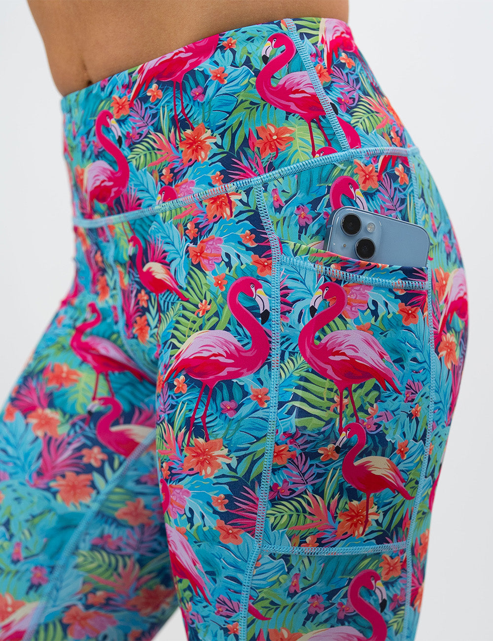 close up of the colorful flamingo leggings against a white background showing a phone in its pocket