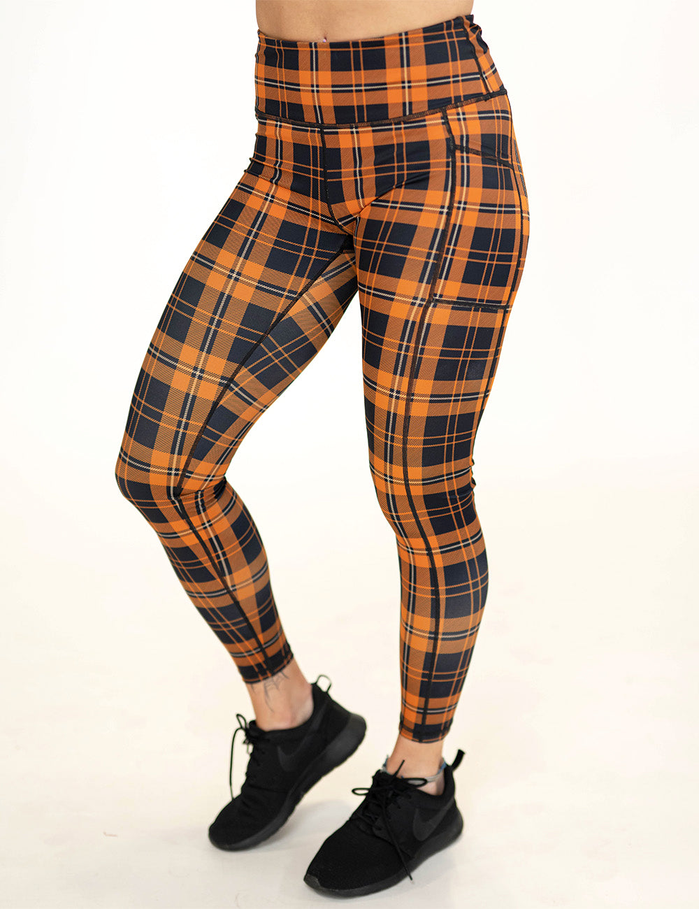 front of the black and orange plaid full length leggings against a white background