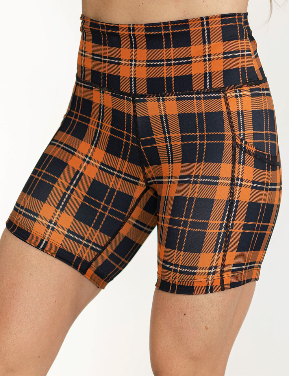 front of the 5 inch black and orange plaid shorts against a white background