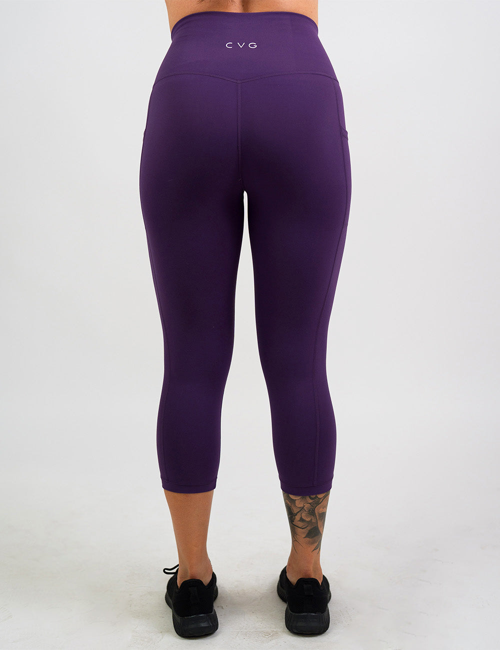 back of the solid purple capri leggings against a white background