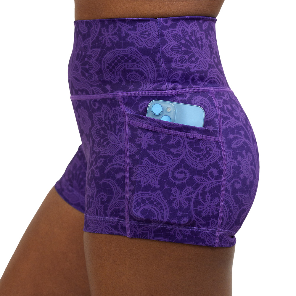close up of the 2.5 inch purple flower artwork shorts with a pone in the pocket against a white background
