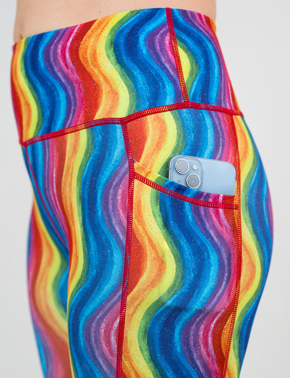 close up of the rainbow waves leggings with a phone in its pocket