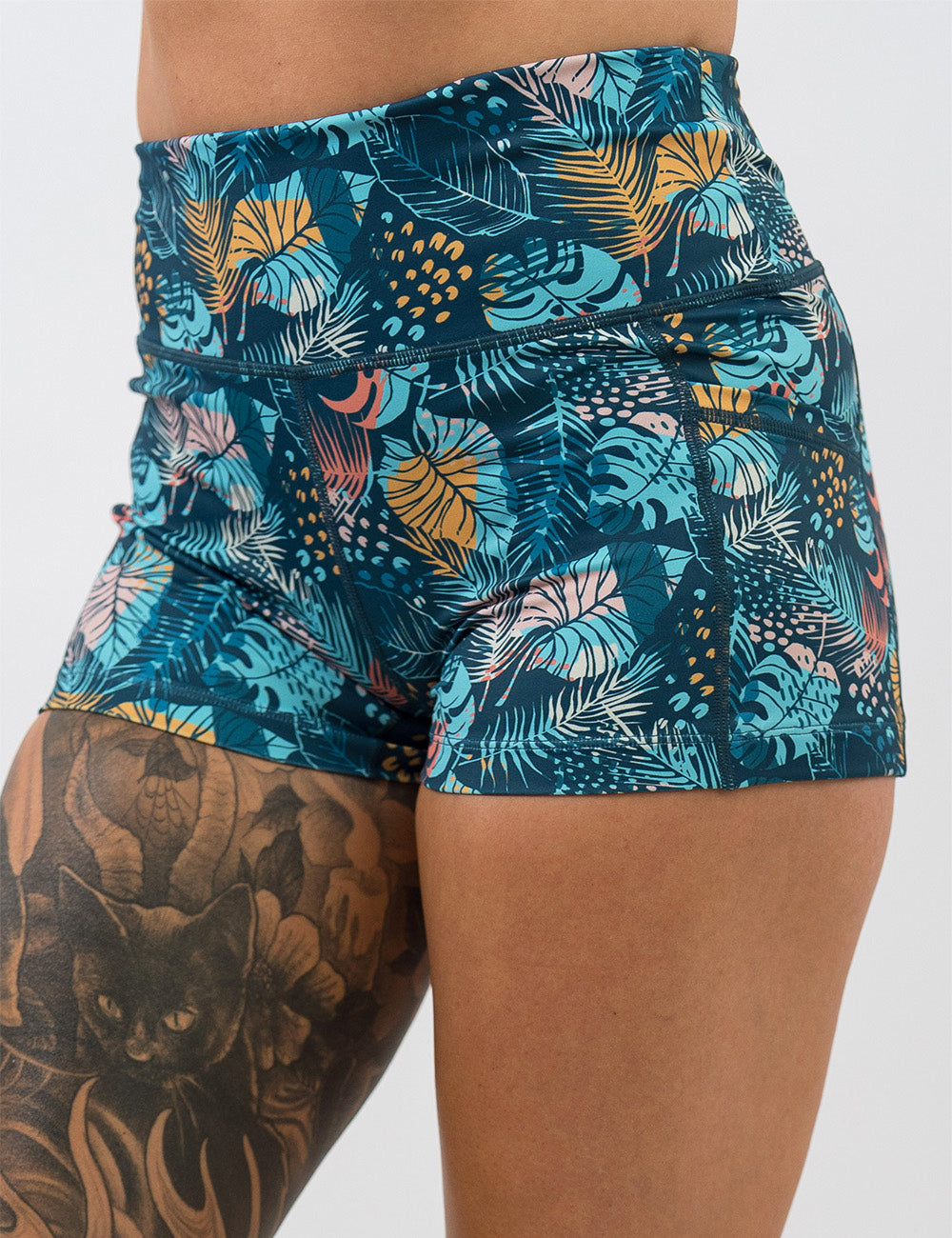 front of the 2.5 inch blue, pink, yellow, and red tropical leaves shorts against a white background