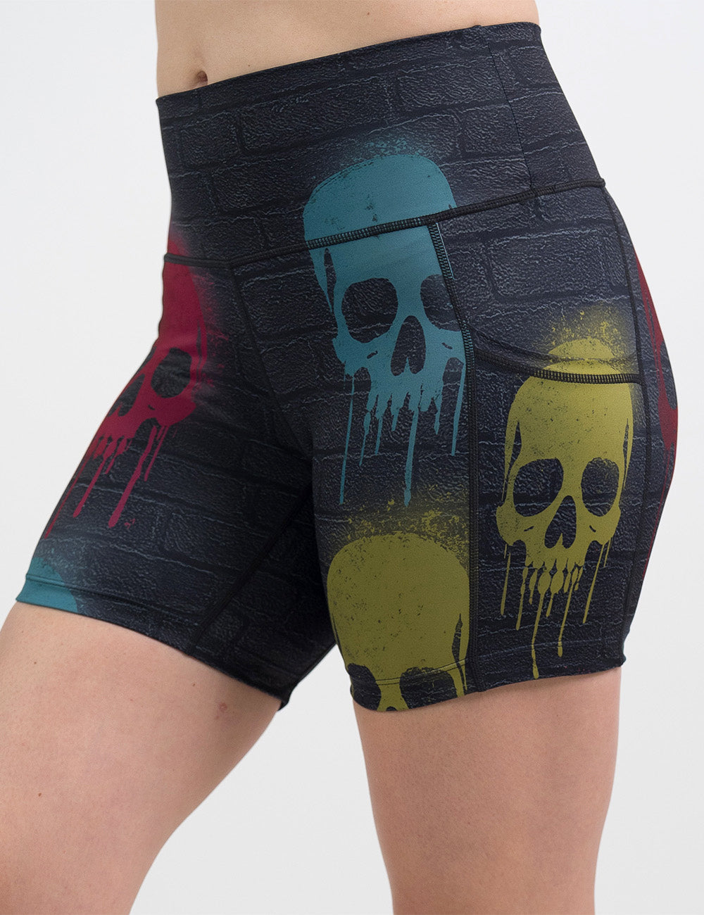 front of the 5 inch black brick pattern with blue, red, and yellow skull spray paint patterns shorts against a white background
