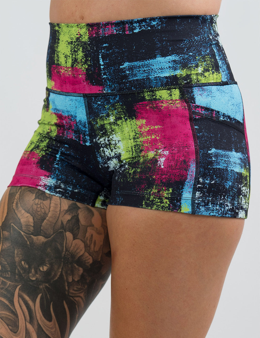 front of the green, pink, and blue grunge pattern 2.5 inch shorts against a white background