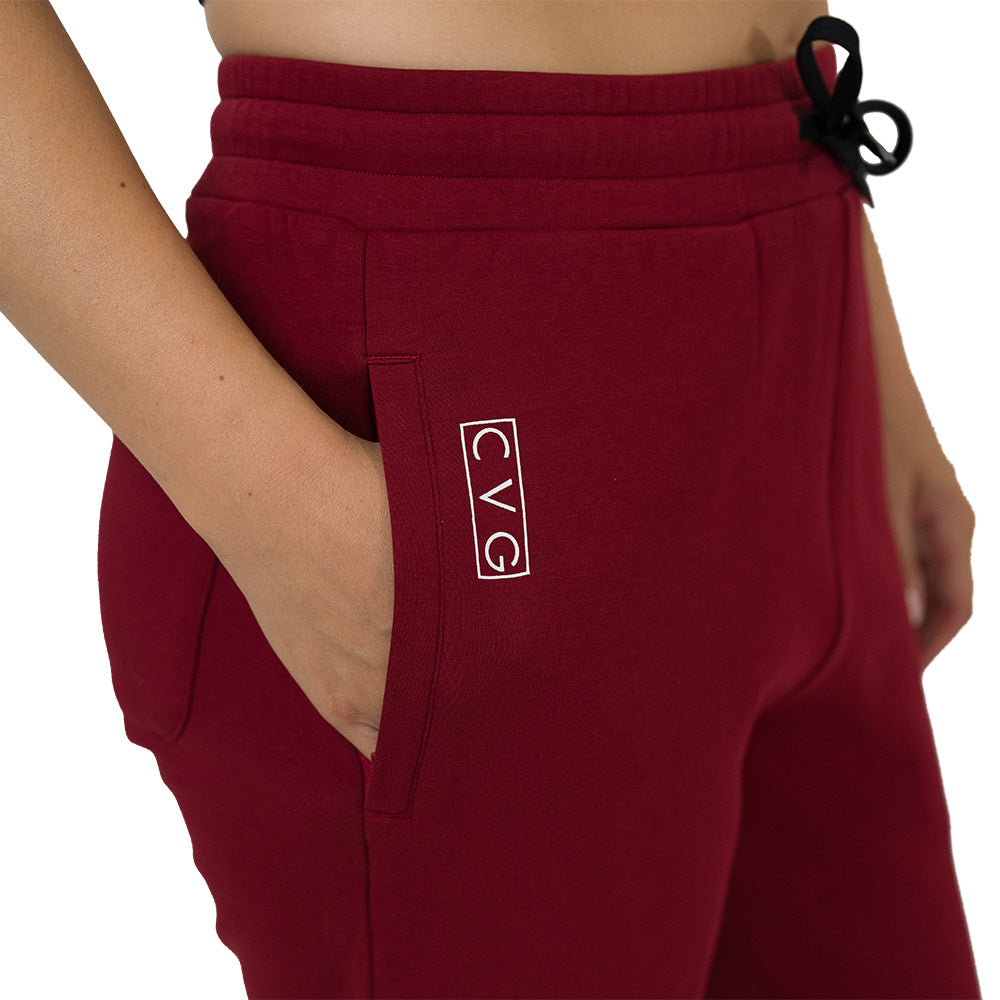 dark red sweatpants with a logo on the pocket against a white background