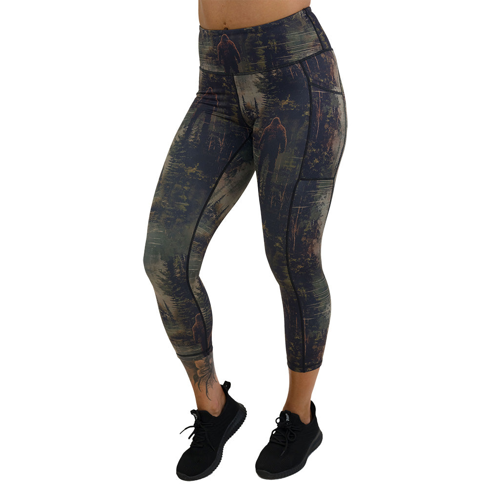 leggings with a forest design and a bigfoot graphic on it