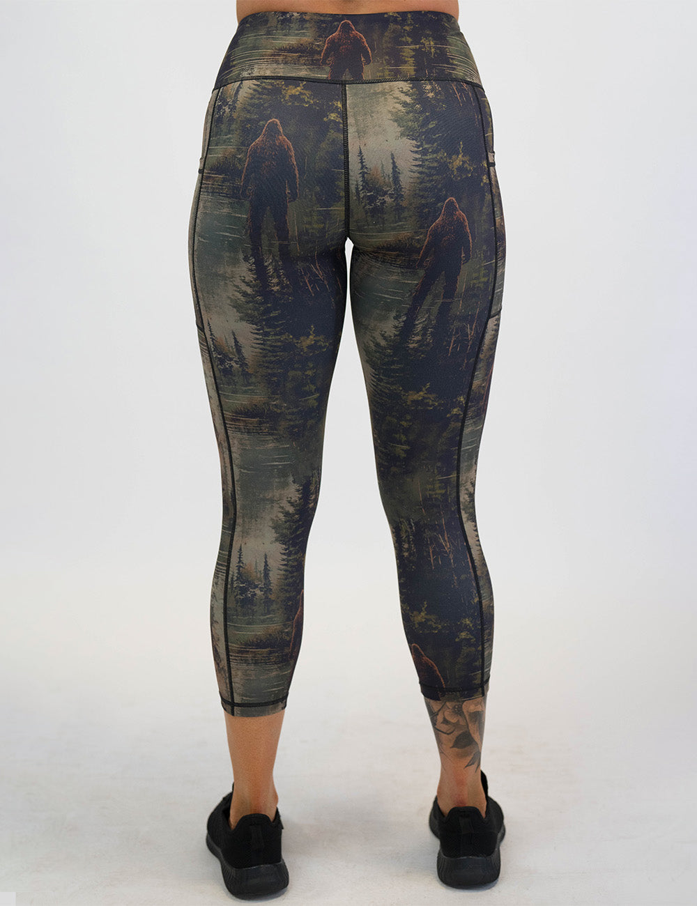 back of the bigfoot in a forest capri leggings against a white background