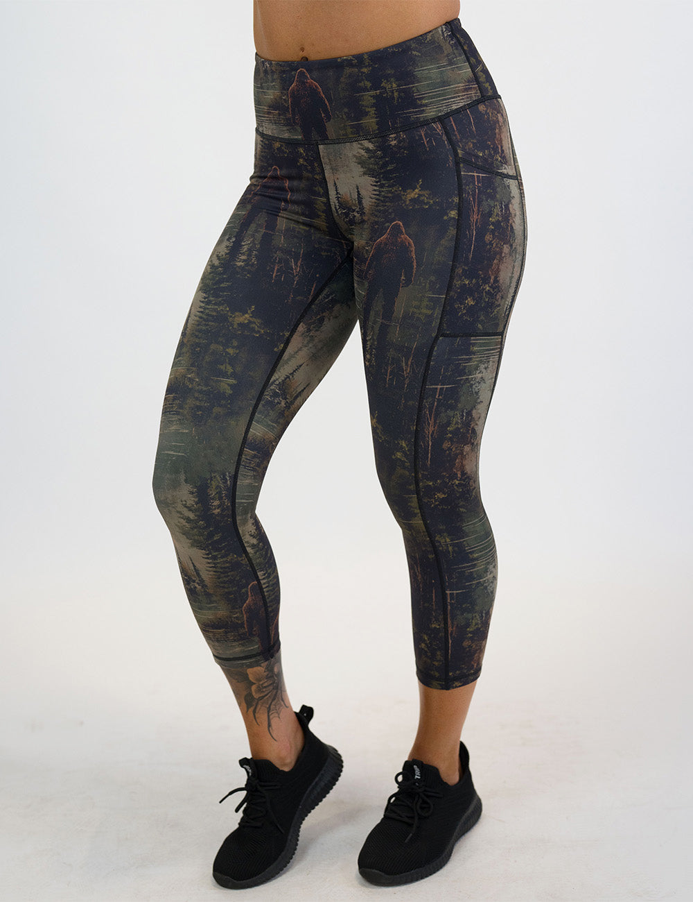 front of the bigfoot in a forest capri leggings against a white background
