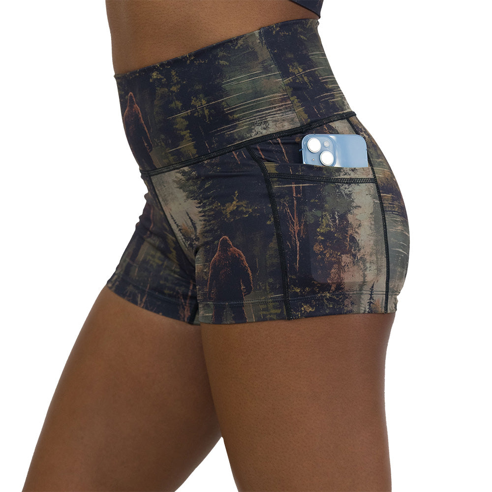 shorts with a forest design and a bigfoot graphic on it