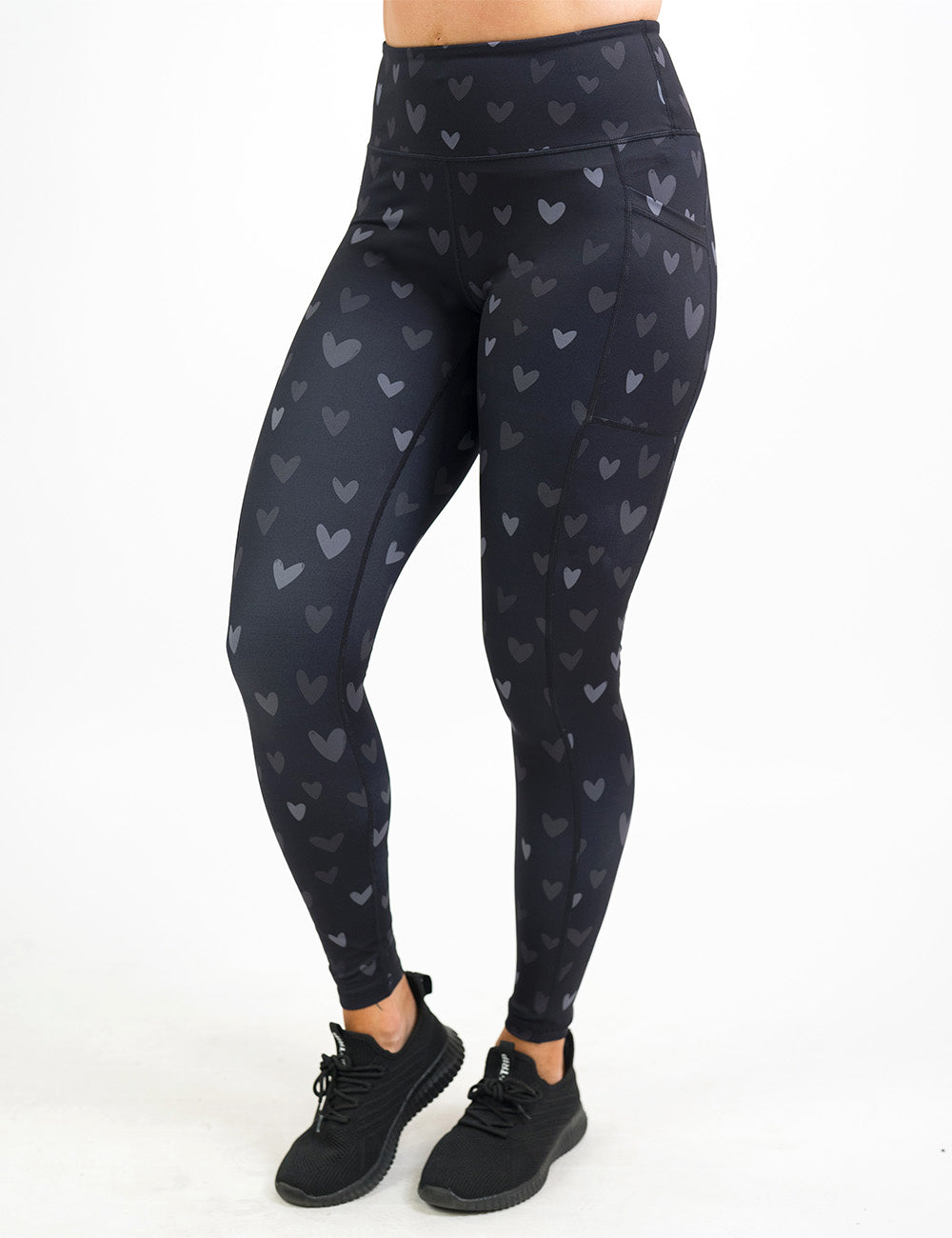 front of the full lengths black leggings with light and dark grey hearts against a white background