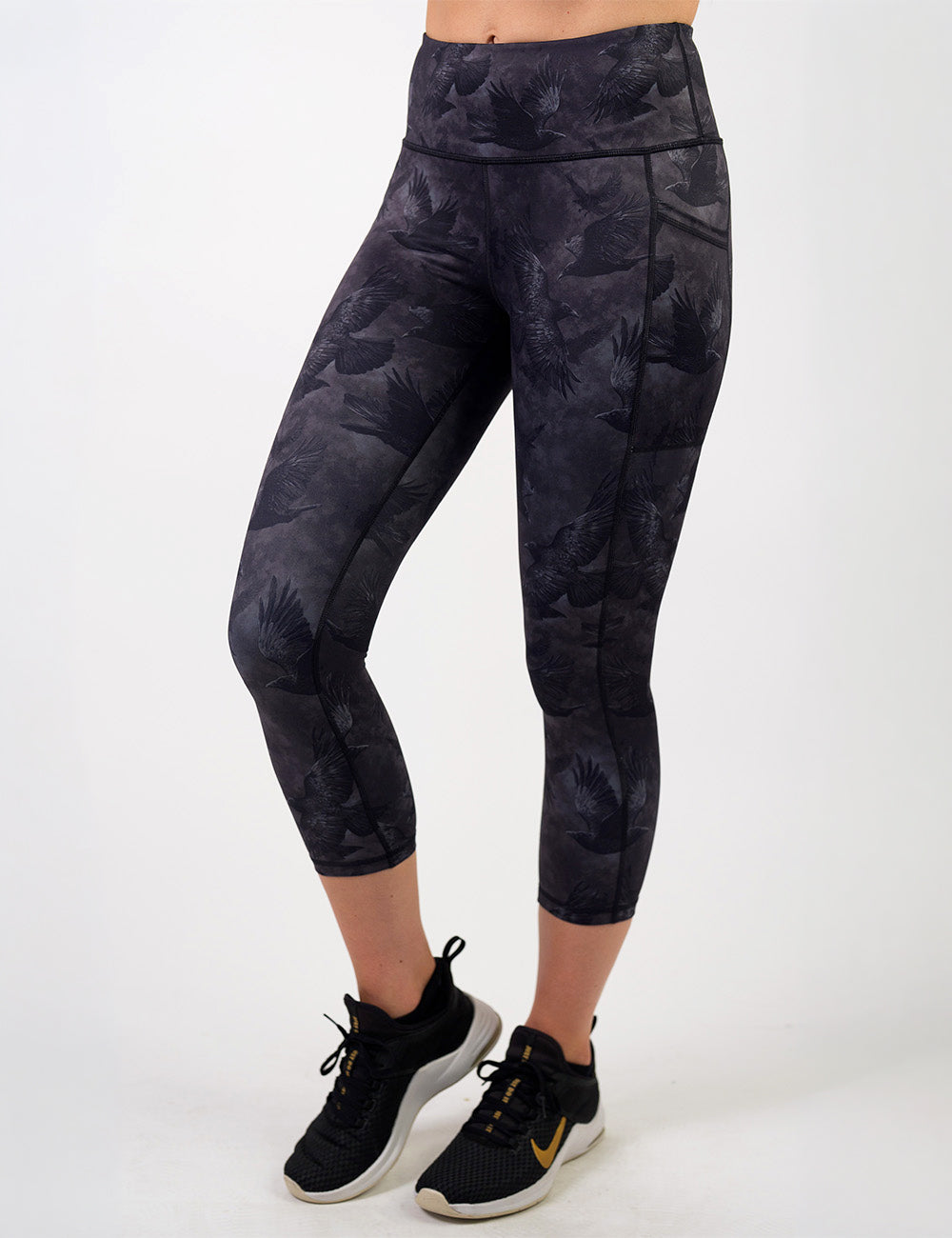 front of the dark ravens against a smokey grey and black background capri leggings against a white background