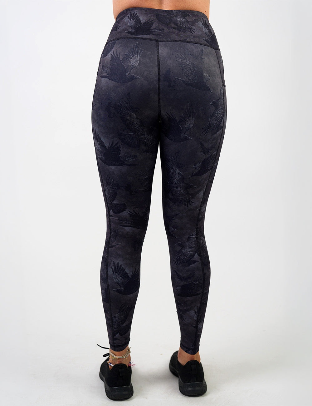 back of the full length dark ravens against a smokey grey and black background full length leggings against a white background