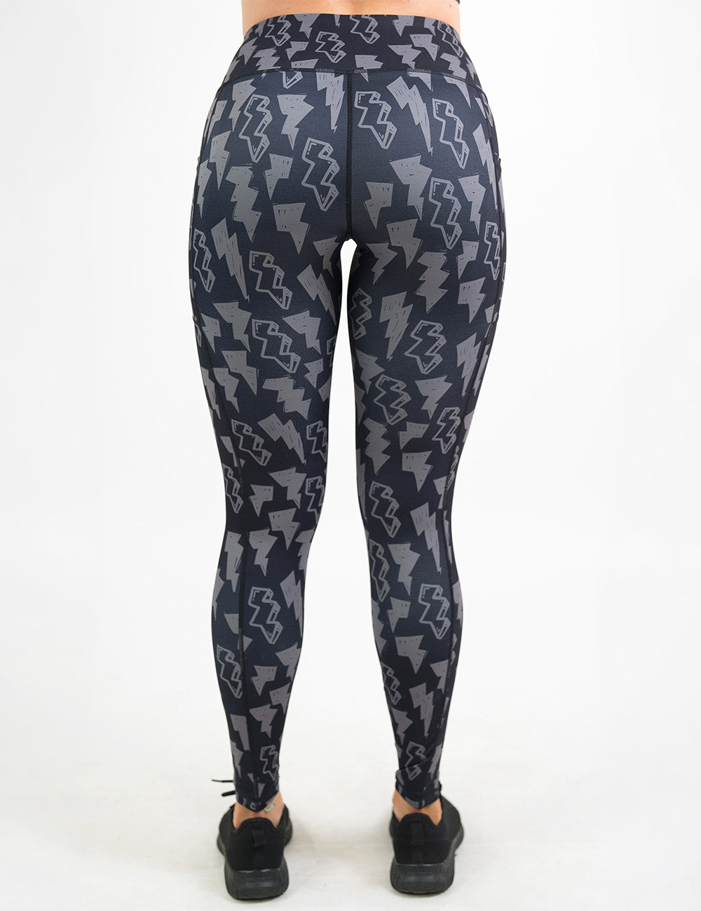back of the full length black leggings with grey thunder bolts against a white background