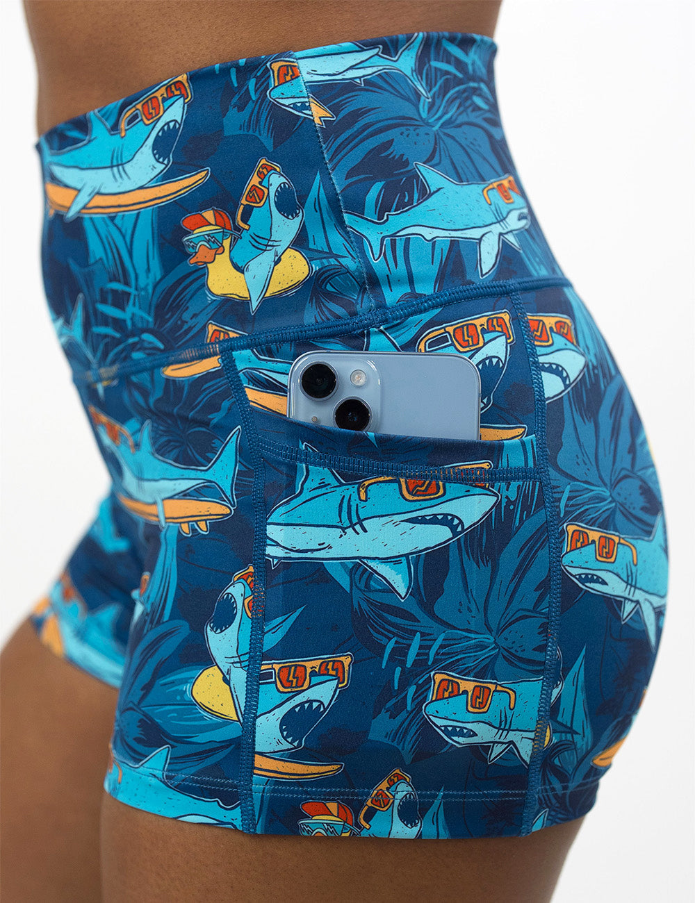 close up of the 2.5 inch cartoon sharks surfboarding with sunglasses shorts with a phone in the pocket