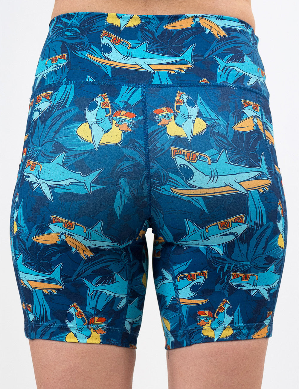 back of the 7 inch cartoon sharks surfboarding with sunglasses shorts against a white background