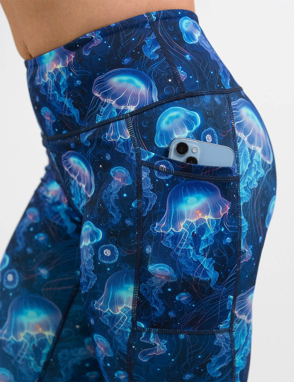 close up of the blue jelly fish pattern leggings with a phone in its pocket