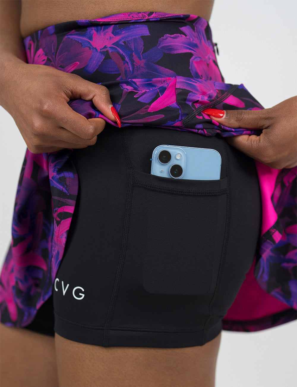 close up of the purple flowers skirt being held up to show the shorts lining underneath with a phone in its pocket