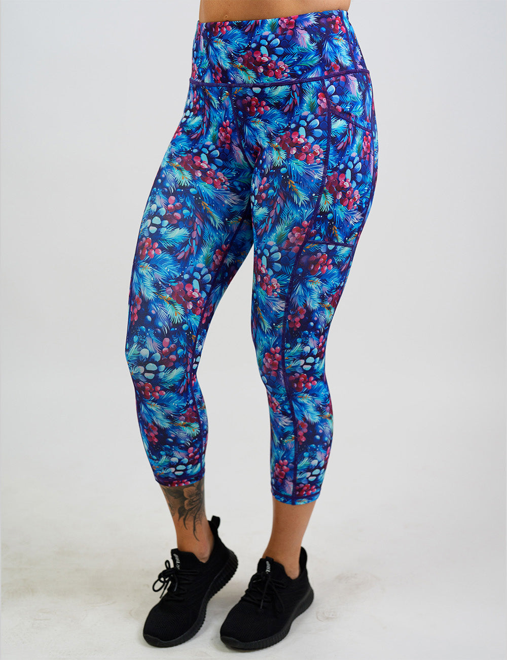 front of the winter berries among blue leaves capri leggings against a white background
