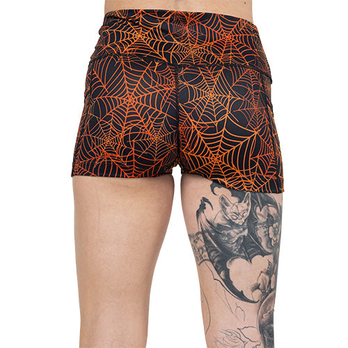 back of black and orange spider web shorts
