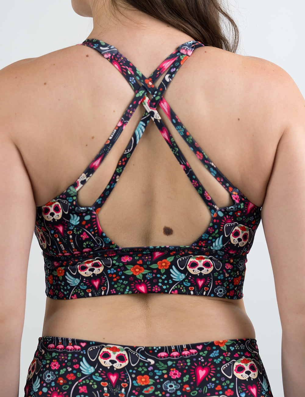 back of the skeleton dogs surrounded by flowers bra against a white background