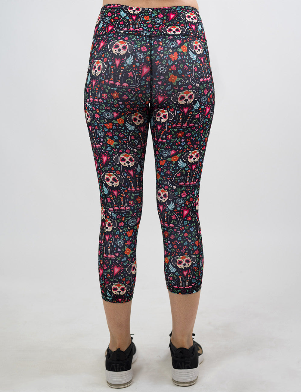 back of the skeleton dogs surrounded by flowers capri leggings against a white background