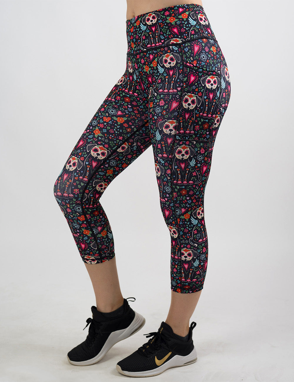 front of the skeleton dogs surrounded by flowers capri leggings against a white background