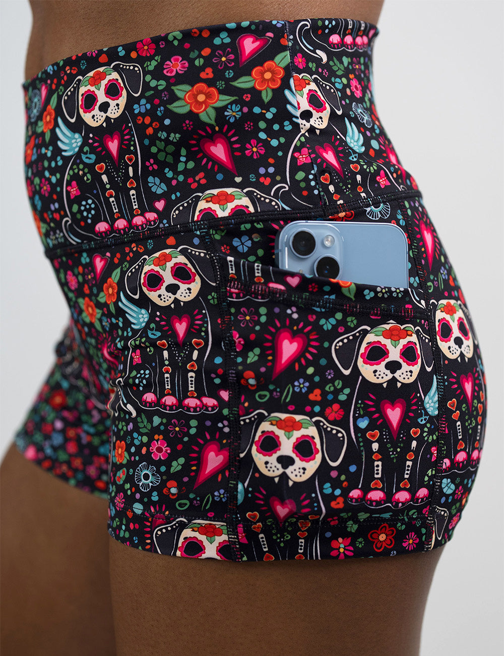 close up of the skeleton dogs surrounded by flowers 2.5 inch shorts with a phone in its pocket