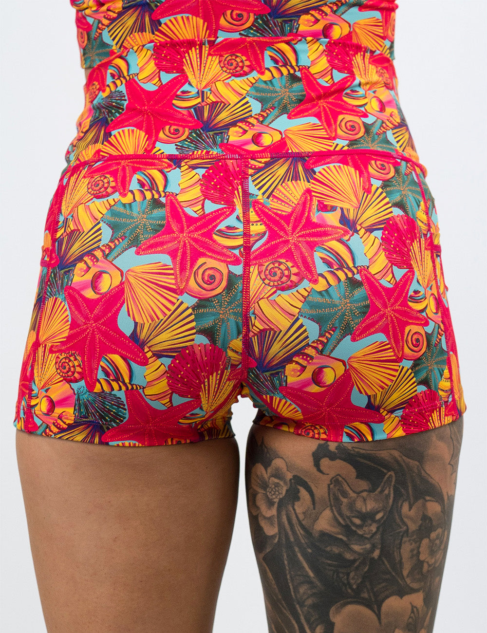 back of the 2.5 inch front of the red starfish with a yellow and blue shell background shorts against a white background