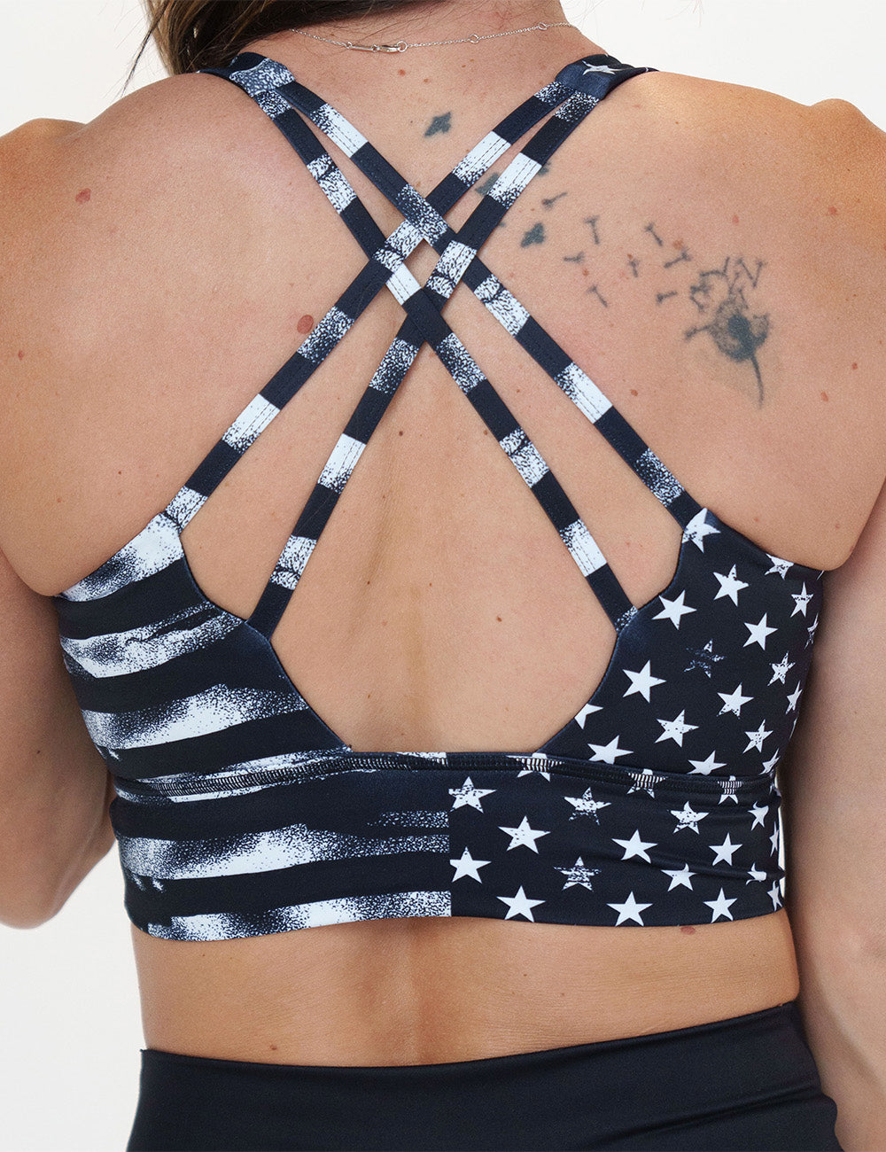 back of the black sports bra with white American flag design on it against a white background