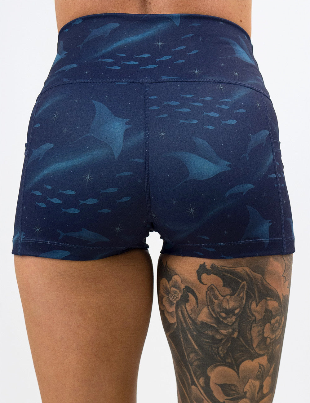 back of the 2.5 inch dark blue ocean filled with sting rays, whales, and fish shorts against a white background