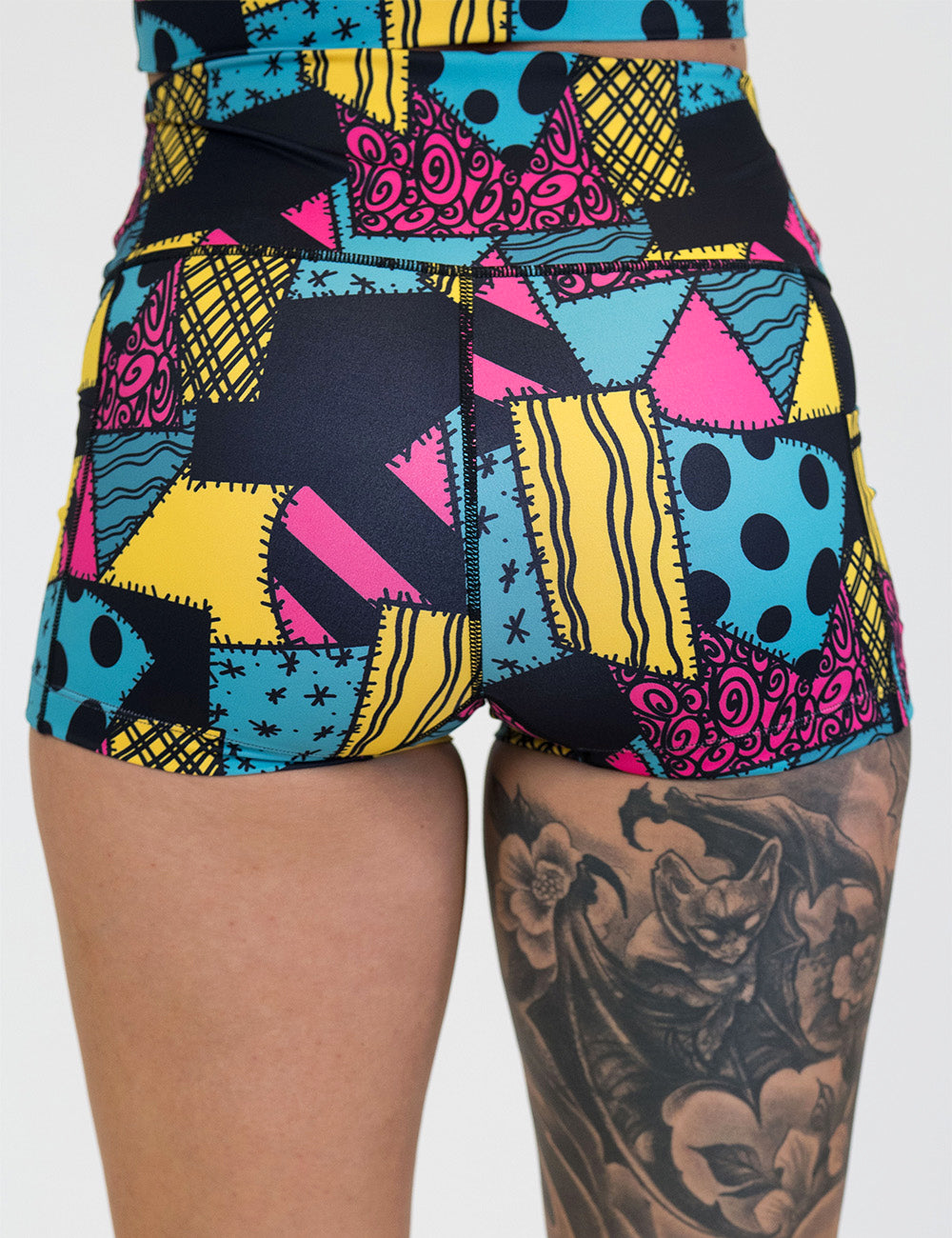 back of the 2.5 inch yellow, teal, and pink patchwork design shorts against a white background