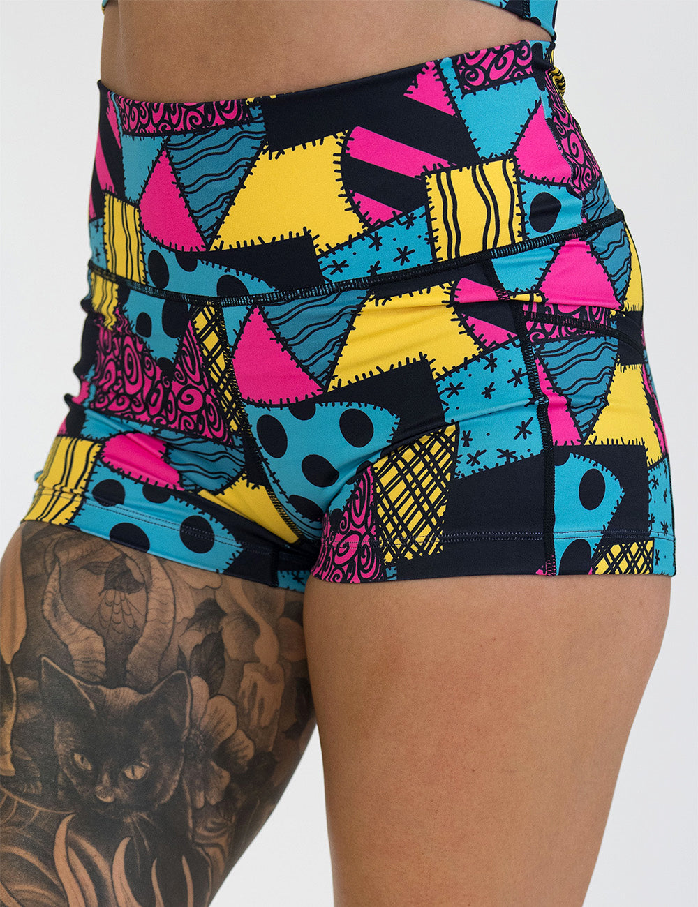 front of the 2.5 inch yellow, teal, and pink patchwork design shorts against a white background