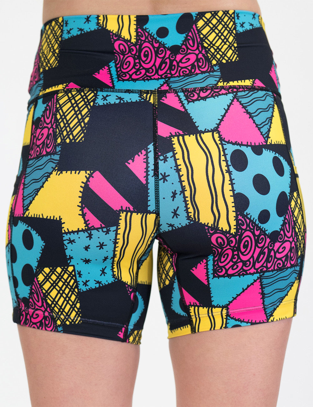 back of the 5 inch yellow, teal, and pink patchwork design shorts against a white background