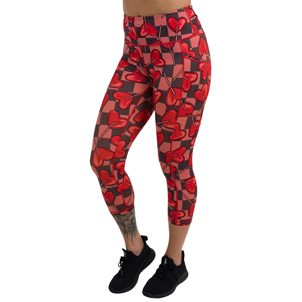 heart lollypops on a checker board background pattern capri leggings facing the side against a white background