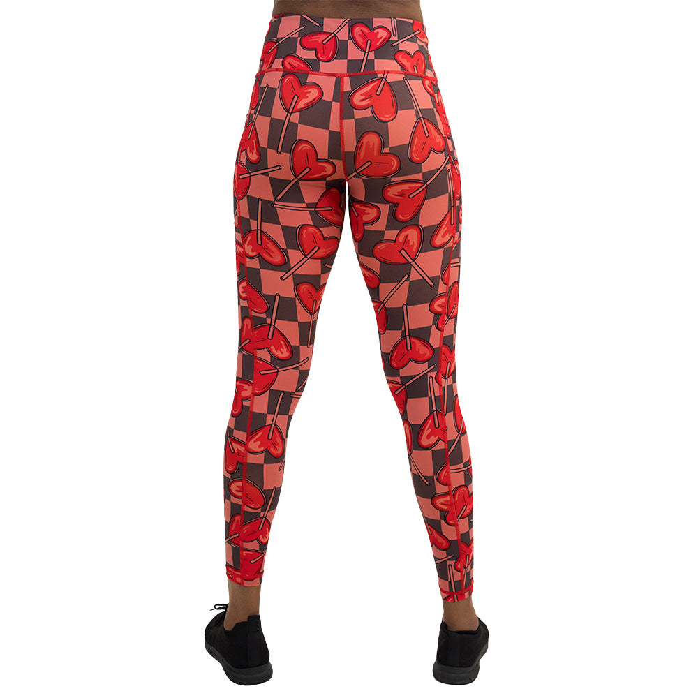 back of the heart lollypops on a checker board background pattern full length leggings against a white background