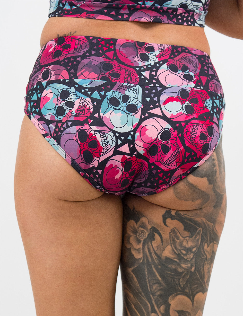 back of the pink and blue skulls pattern swim suit bottoms against a white background