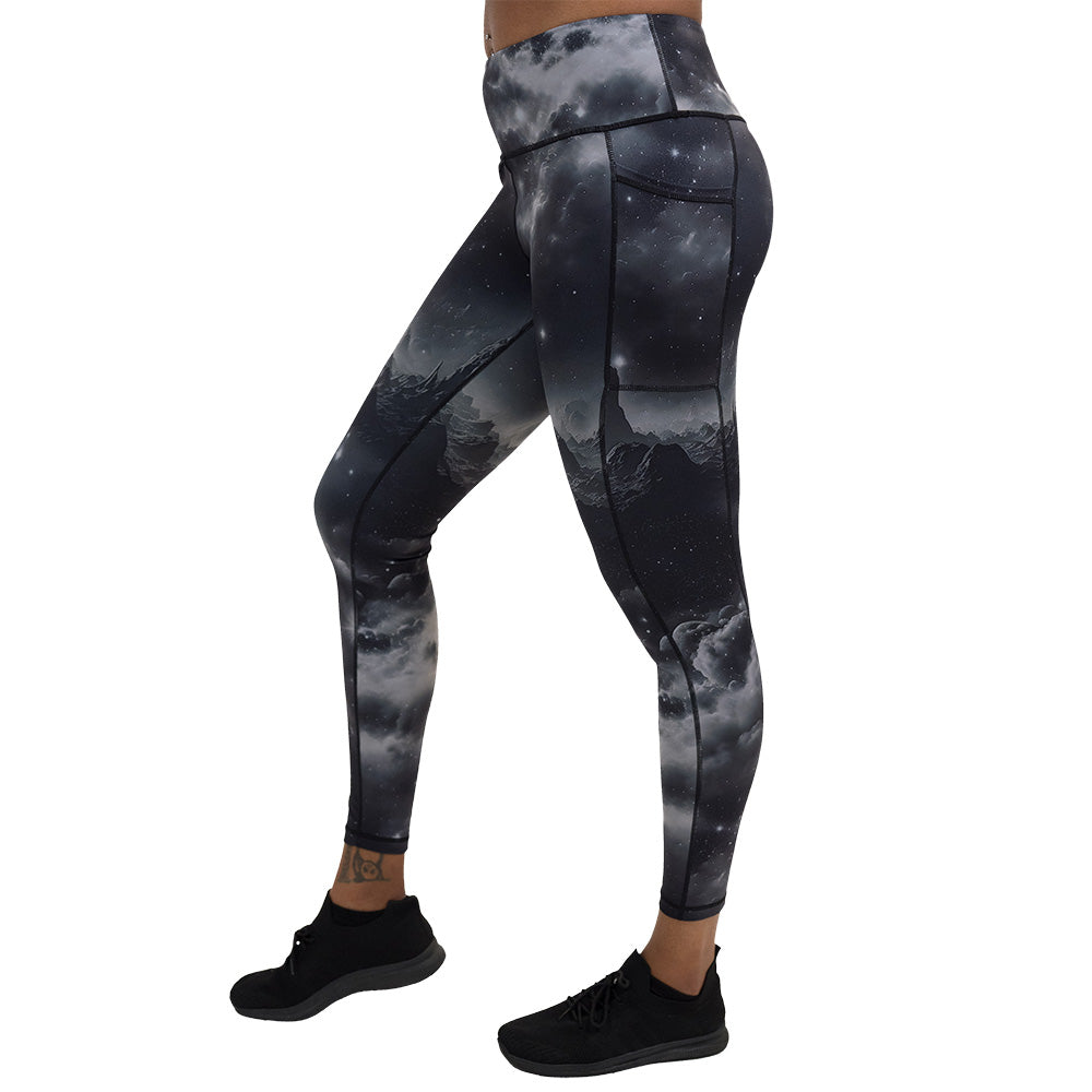 full length black leggings with mountain and star pattern facing the side against a white background