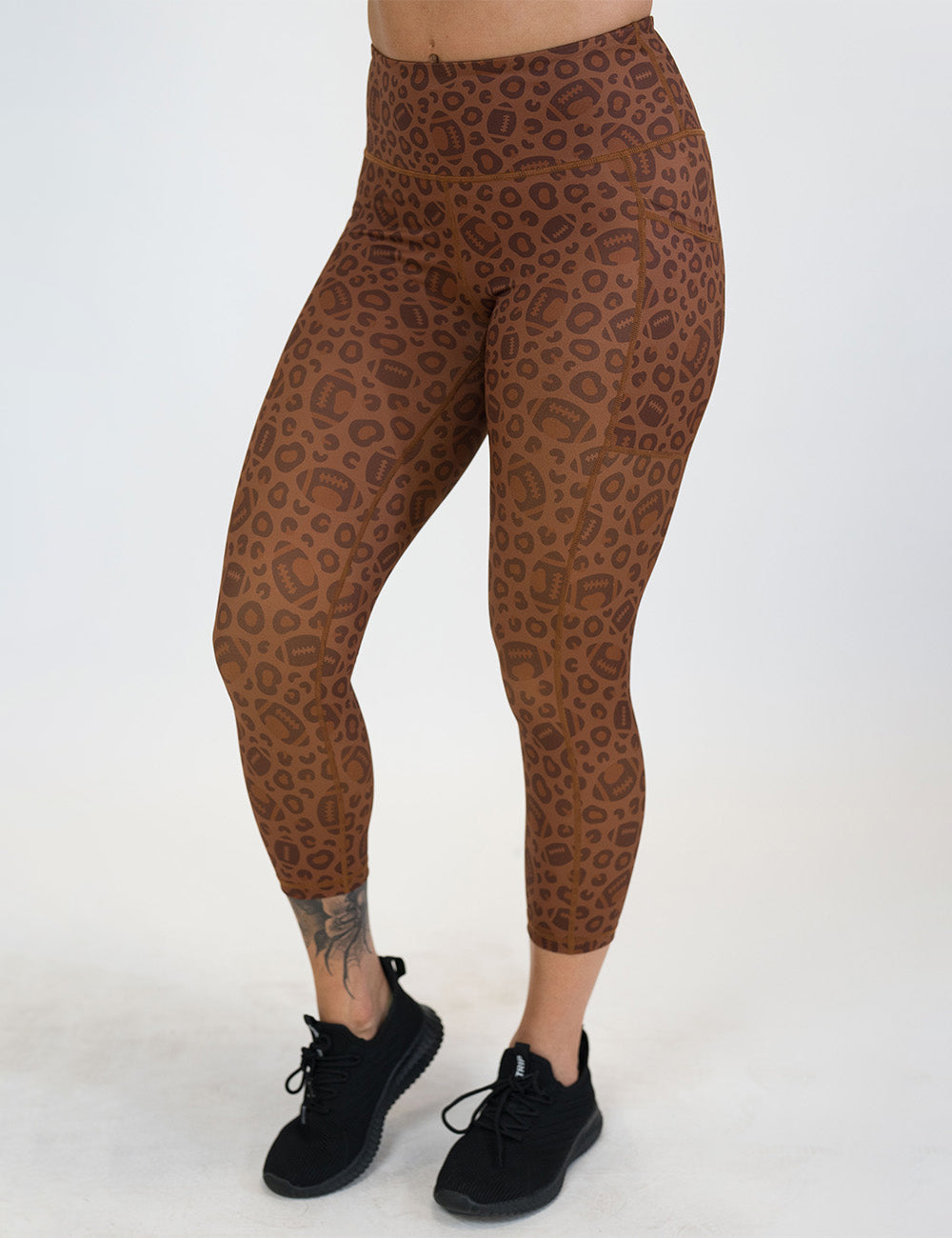 front of the football themed brown leopard print capri leggings against a white background