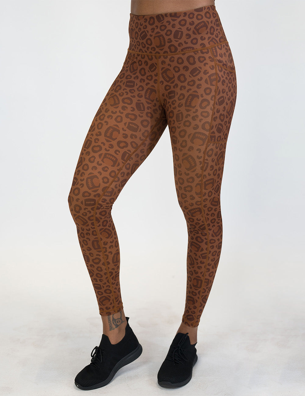 front of the football themed brown leopard print full length leggings against a white background