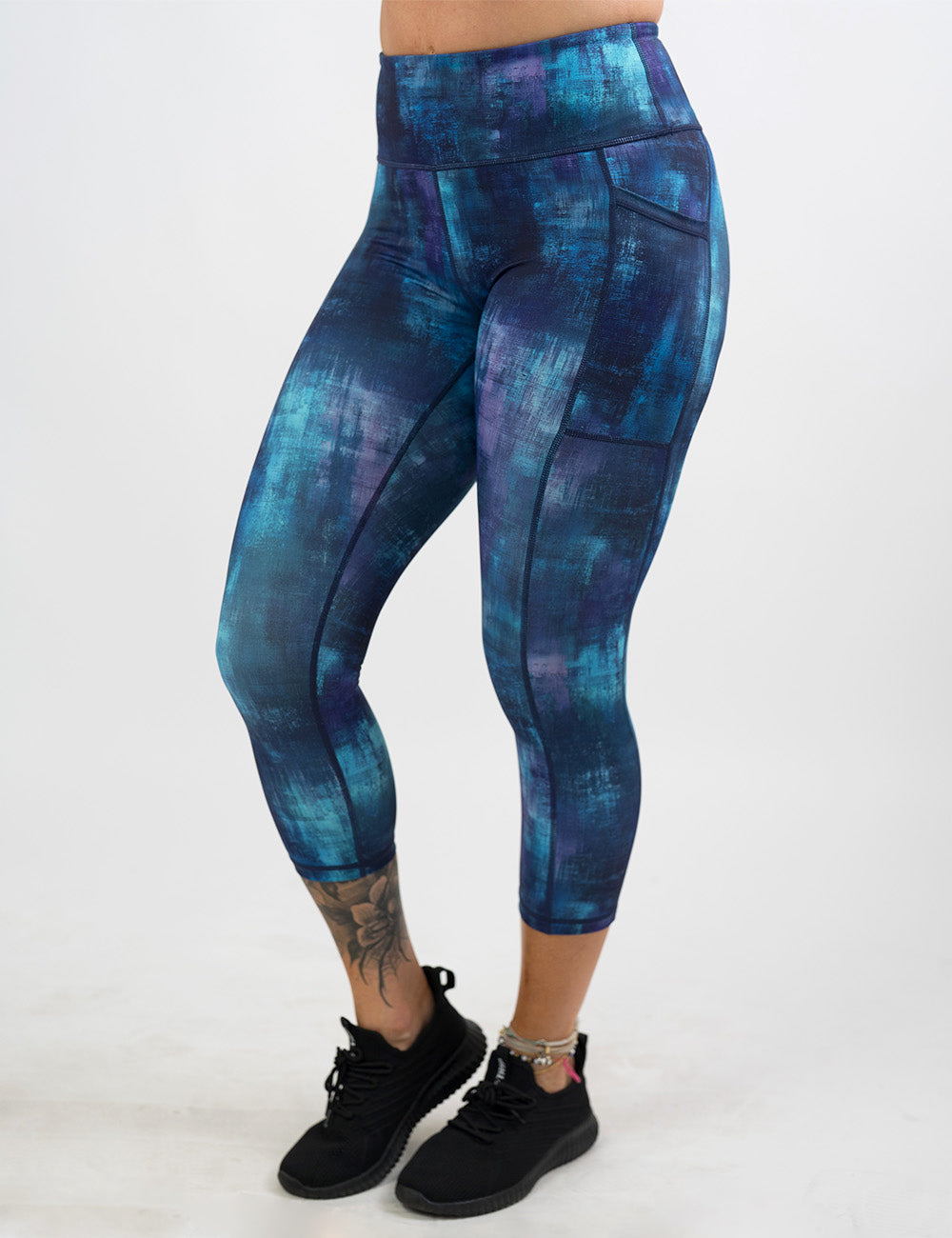 front of the blue, teal, and purple grunge concrete pattern full length leggings against a white background