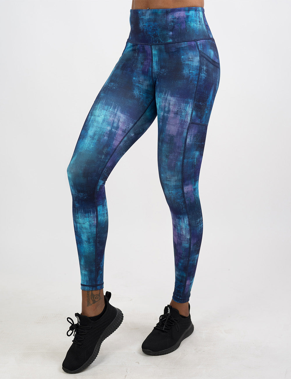 front of the blue, teal, and purple grunge concrete pattern full length leggings against a white background