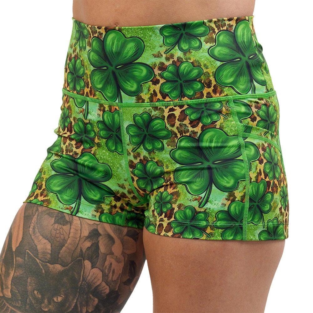 close up of the clover pattern against a cheetah print and green background 2.5 inch shorts against a white background