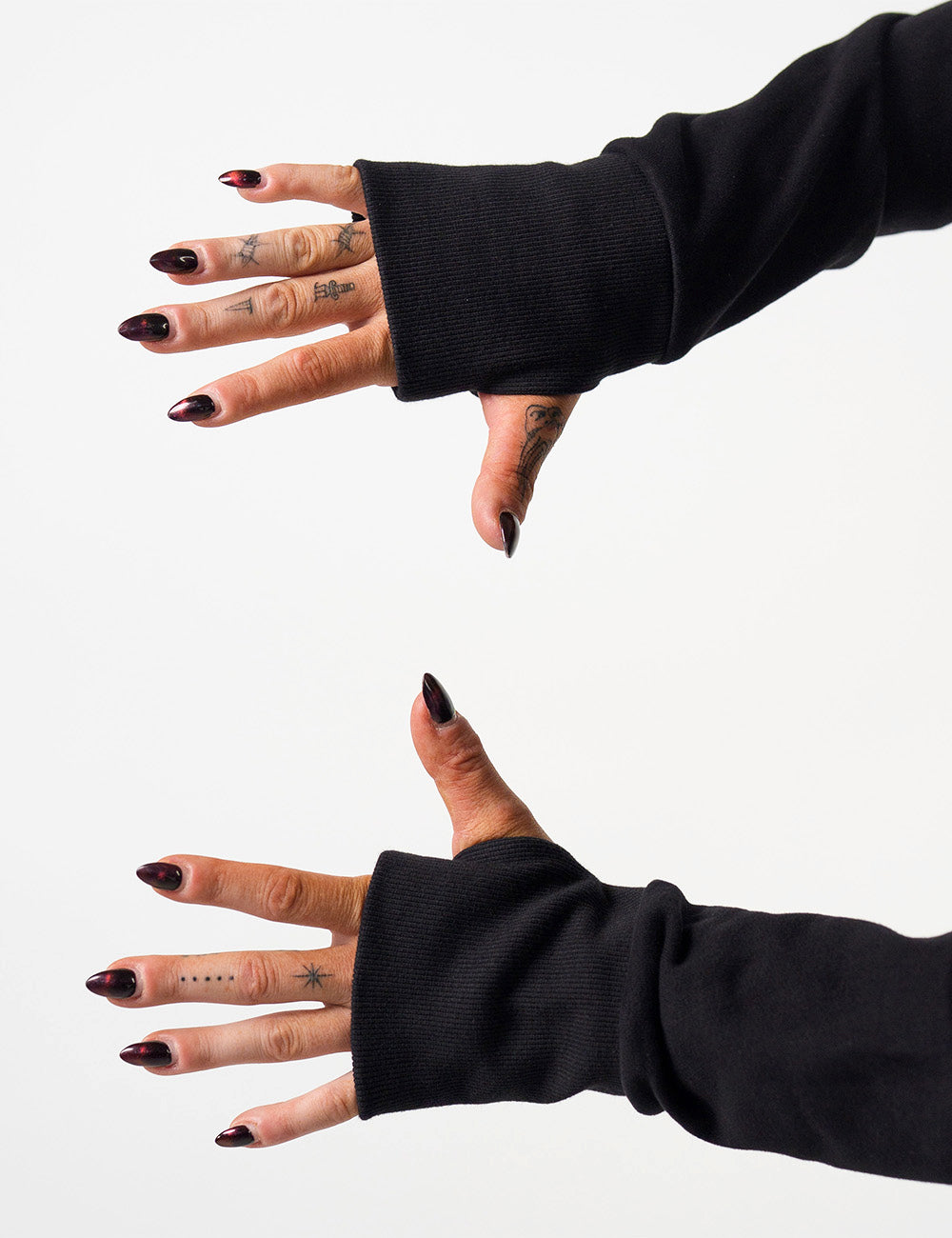 close up of the thumb holes in the sleeves of the black hoodie