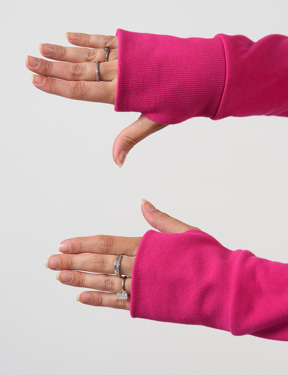 close up of the thumbholes in the pink hoodie's sleeves