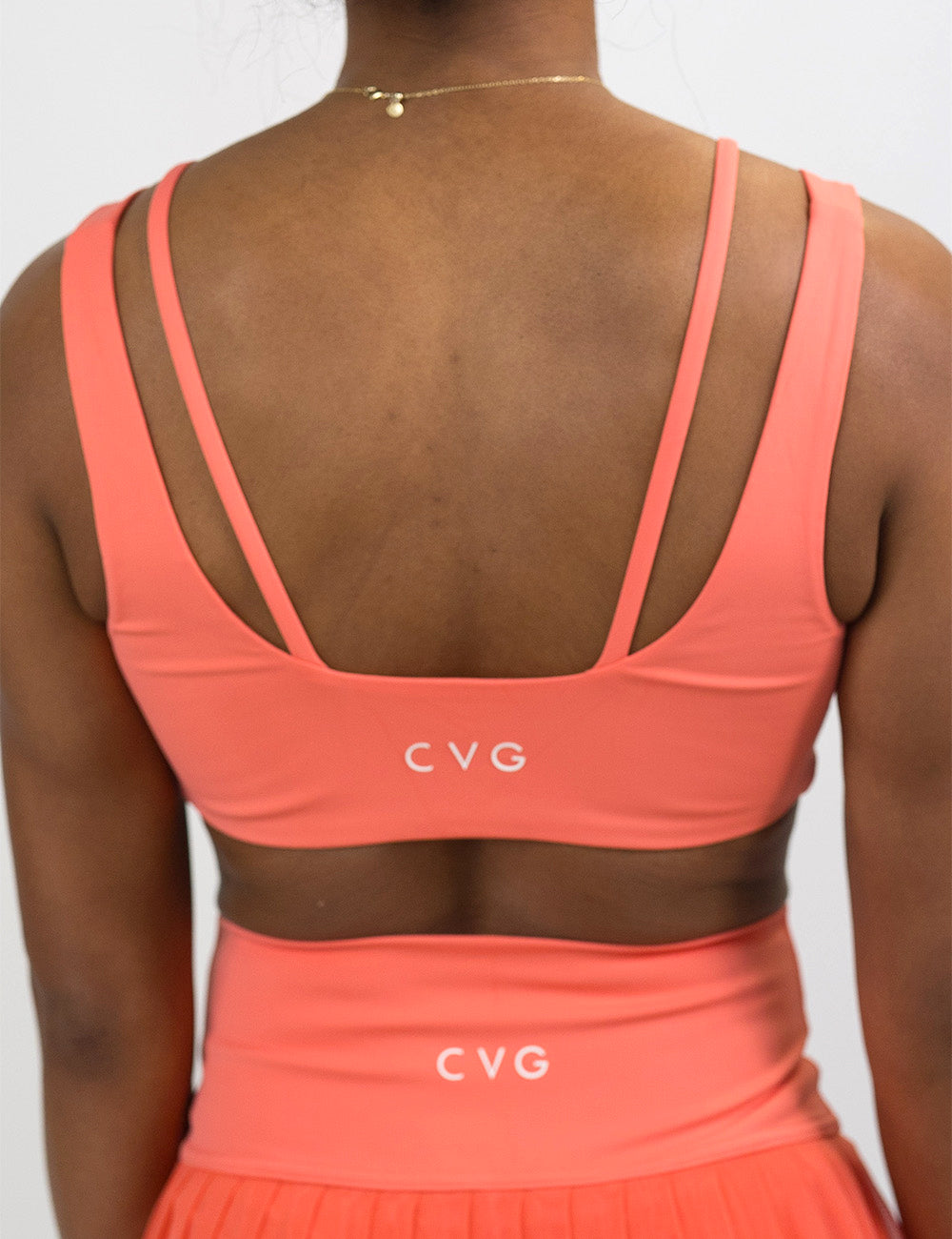 back of the solid orange vista bra against a white background, surprise drop